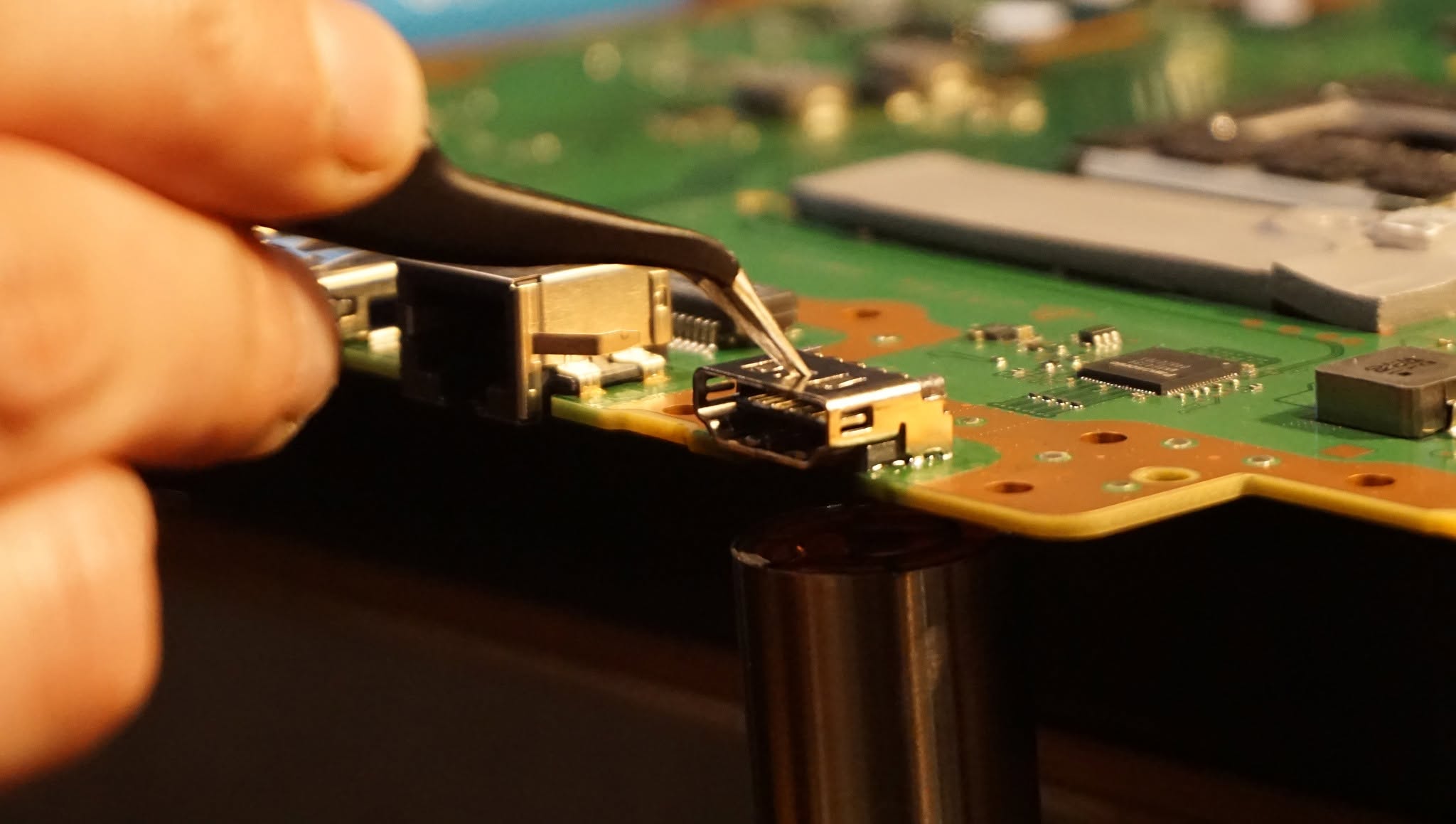 Real MPR console HDMI port repair with precision tweezers